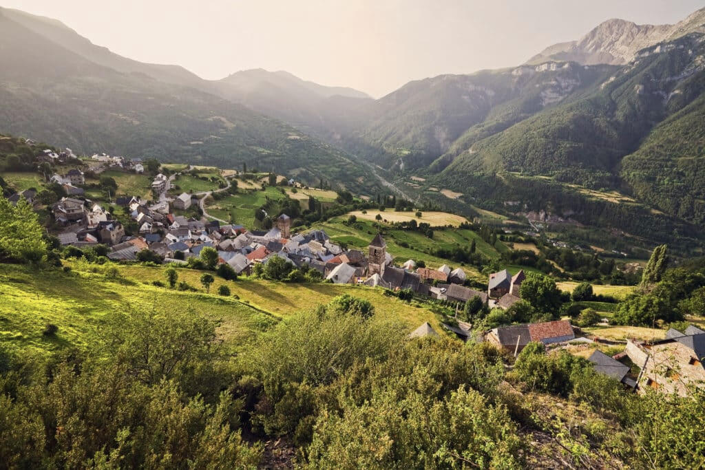 Valle con un pequeño pueblo rodeado de montañas en Aragón, ideal para producciones cinematográficas